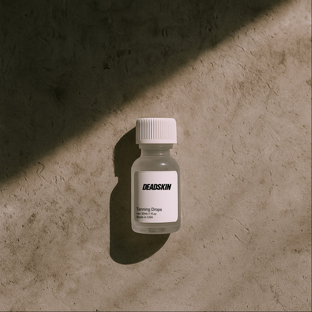 Small bottle labeled 'DEADSKIN' on a textured surface with a soft shadow.