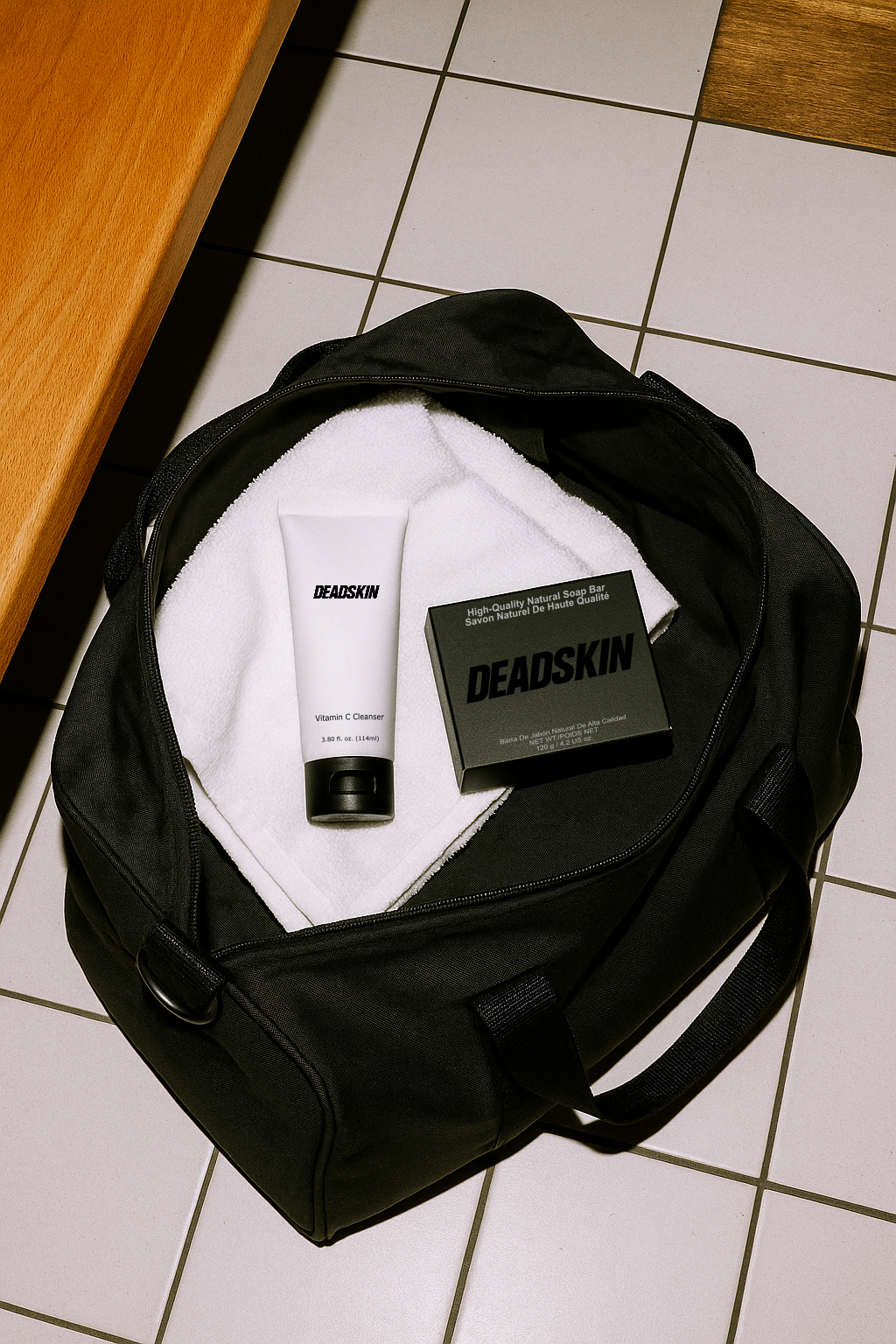 Skin Care for men ; Black duffel bag with Deadskin products on a tiled floor